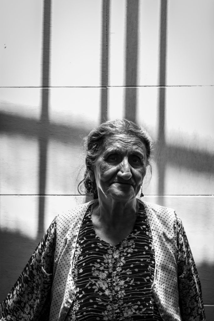 a woman standing in front of a wall with bars on it